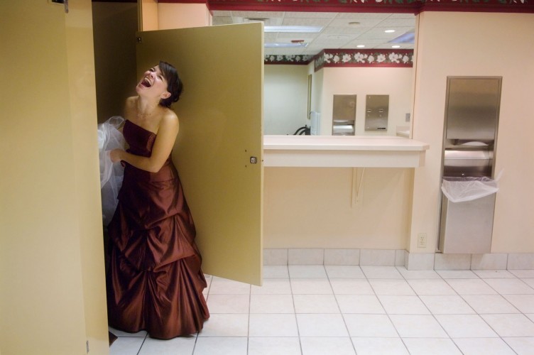 Bridesmaid and bride get a laugh in the bathroom